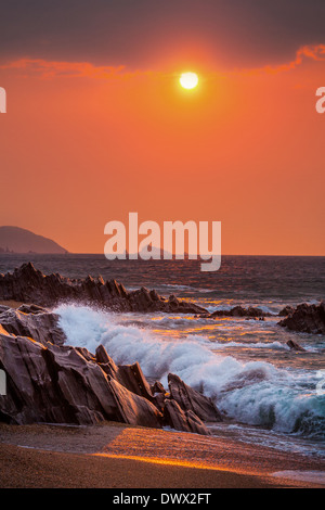 Sunrise view of waves crashing onto the rocks at Slapton Sands, Devon, UK Stock Photo