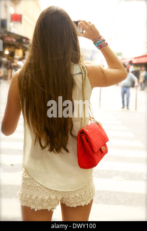 Young woman photographing street with mobile phone Stock Photo