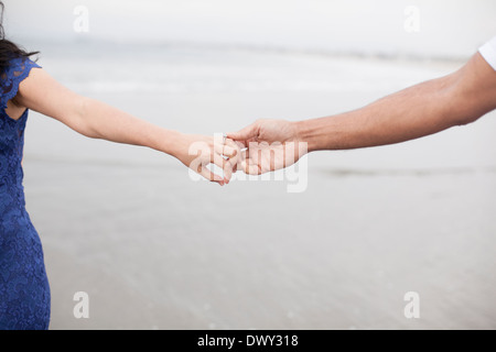 Engaged couple holding hands on beach Stock Photo