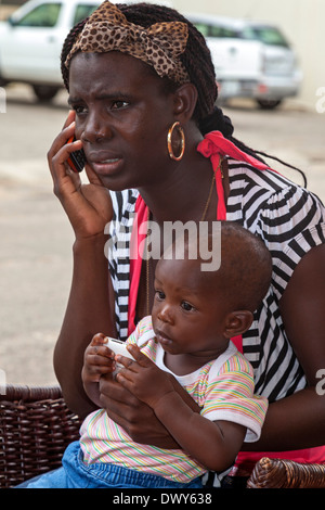 Woman with baby talking on mobile phone, Osu, Accra, Ghana, Africa Stock Photo