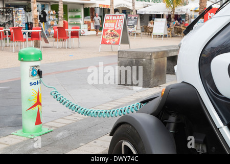 Renault Twizy battery-powered electric car plugged in to a Sol-lar battery charging point on roadside in Canary Islands Spain Stock Photo