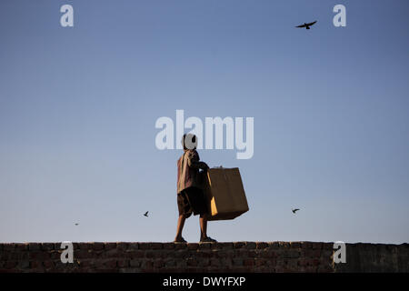 New Delhi, India. 13th Mar, 2014. A boy walks at the top of a wall with a litterbin in Old Delhi, India, March 13, 2014. Credit:  Zheng Huansong/Xinhua/Alamy Live News Stock Photo