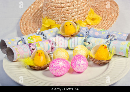 An image showing the concept of Easter with yellow chicks and colored eggs Stock Photo