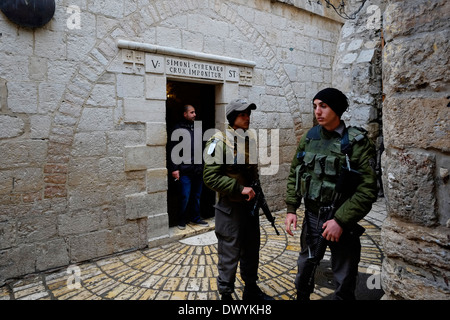Members of the Israeli Security Forces stand guard next to the Chapel of Simon of Cyrene, at the 5th station of the cross in Via Dolorosa street believed to be the path that Jesus walked on the way to his crucifixion in the Old City. East Jerusalem, Israel Stock Photo
