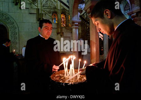 Students of the Armenian Patriarchate Seminary light candles inside the Church of Holy Sepulchre in East Jerusalem Israel Stock Photo