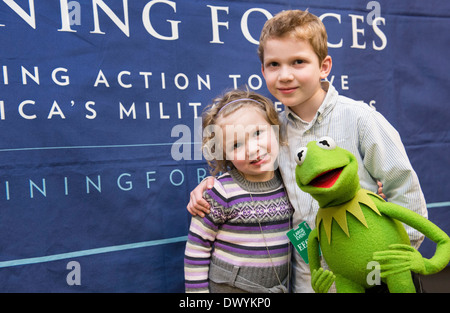 Military children pose with Kermit the Frog during a movie screening of the new Muppets movie, 'Muppets Most Wanted', at the White House March 12, 2014 in Washington, DC. Stock Photo