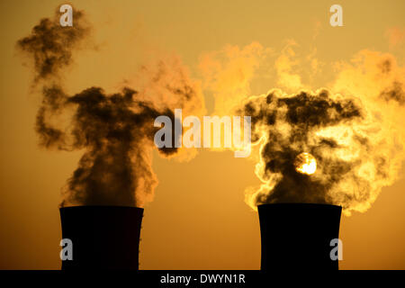 Grafenrheinfeld, Germany. 14th Mar, 2014. The sun sets behind the nuclear power plant Grafenrheinfeld while the two cooling towers give off steam in Grafenrheinfeld, Germany, 14 March 2014. Photo: DAVID EBENER/dpa/Alamy Live News Stock Photo