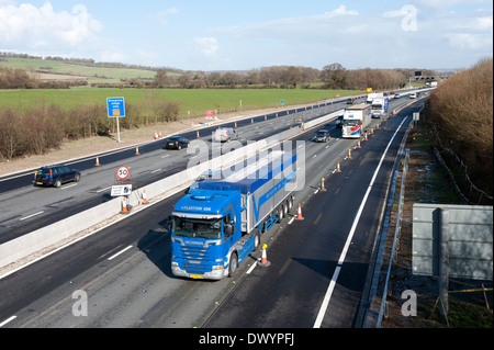 Traffic passing a coned off area on the M25 motorway in Surrey, UK Stock Photo