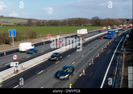 Traffic passing a coned off area on the M25 motorway in Surrey, UK Stock Photo