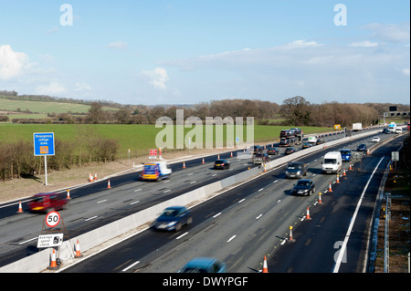 Traffic passing a coned off area on the M25 motorway in Surrey, UK Stock Photo