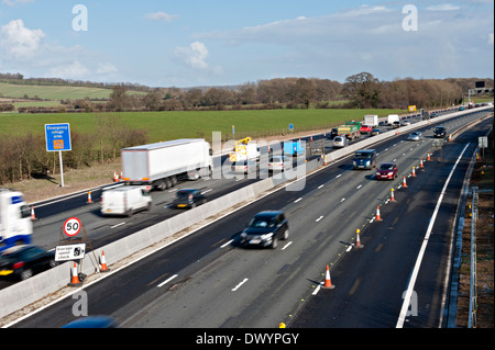 Traffic passing a coned off area on the M25 motorway in Surrey, UK Stock Photo