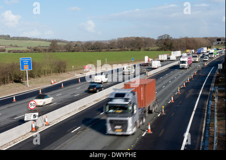 Traffic passing a coned off area on the M25 motorway in Surrey, UK Stock Photo