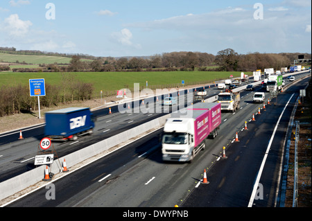 Traffic passing a coned off area on the M25 motorway in Surrey, UK Stock Photo