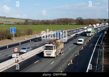 Traffic passing a coned off area on the M25 motorway in Surrey, UK Stock Photo