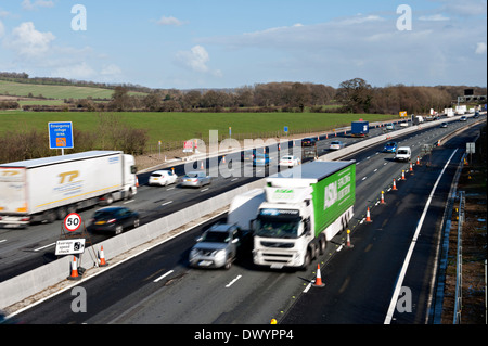 Traffic passing a coned off area on the M25 motorway in Surrey, UK Stock Photo