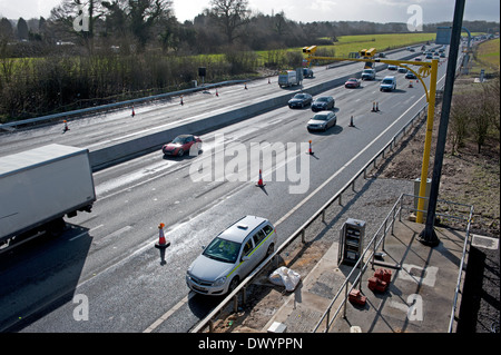 Traffic passing a coned off area on the M25 motorway in Surrey, UK Stock Photo