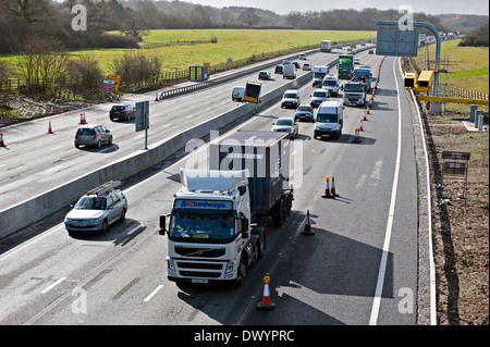 Traffic passing a coned off area on the M25 motorway in Surrey, UK Stock Photo