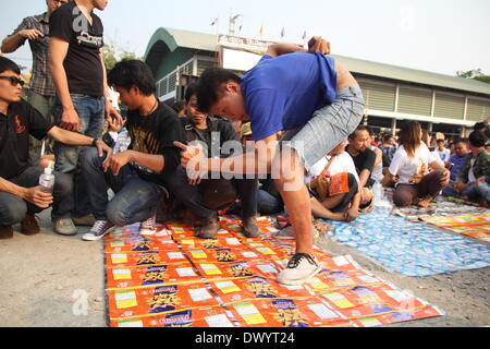 Nakhon Pathom , Thailand. 15th Mar 2014. Devotee enters in a state of trance as he tries to pay his respect to a statue of Khru Sak during the celebration of the annual Tattoo festival at Wat Bang Phra. Thousands of believers from all over Thailand come to take partto the temple's monks who are master tattooist. In Thai culture the tattoo is worn as a symbol of spiritual and physical protection, many believe that the tattoo has mystical powers. Many tattoo fanatics choose to have monkeys and tigers as well as the Khmer/Cambodia ancient script on their bodies. Credit:  John Vincent/Alamy Live N Stock Photo