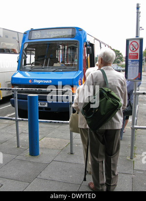 Ellderly man with backpack & old aged pensioners queueing & waiting at Chichester bus station Chichester West Sussex UK Stock Photo