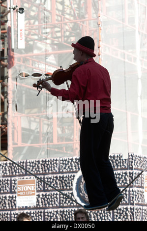 Busker on tightrope playing violin, Bath, Somerset, England, UK Stock Photo