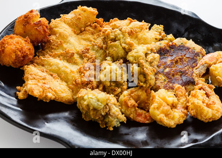 Fresh shrimp, oysters, grouper, and a crab cake all fried and served with hush puppies. Stock Photo