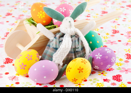 Cute Easter bunny rabbit with a little wheelbarrow and eggs Stock Photo