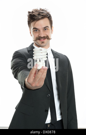 Young man in business suit holds a CFL compact fluorescent lightbulb Stock Photo