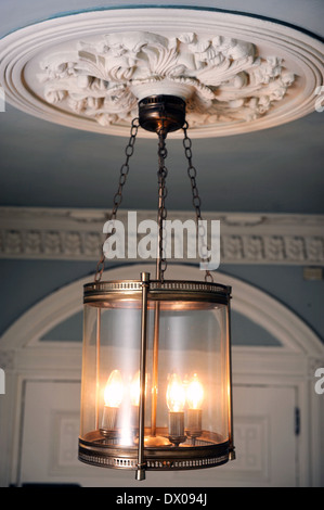 An unusual brass lantern hanging from an ornate plaster ceiling rose in a Georgian townhouse in Bath UK Stock Photo