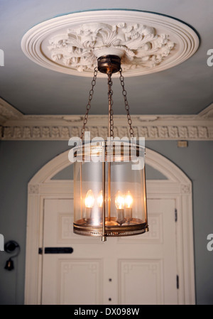 An unusual brass lantern hanging from an ornate plaster ceiling rose in a Georgian townhouse in Bath UK Stock Photo
