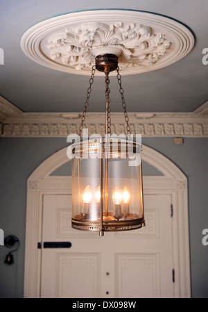 An Unusual Brass Lantern Hanging From An Ornate Plaster Ceiling