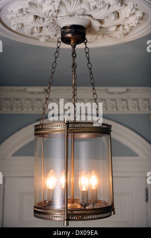An unusual brass lantern hanging from an ornate plaster ceiling rose in a Georgian townhouse in Bath UK Stock Photo