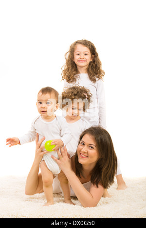 Happy mom with three children sitting on fur carpet home Stock Photo