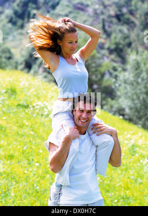Enamoured young couple, he is carrying her piggyback on, joy, fun Stock Photo