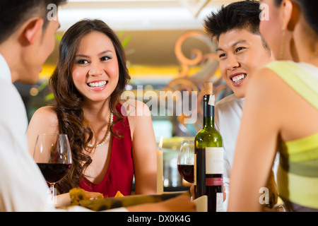 Four Asian Chinese business people having dinner in elegant club restaurant or hotel Stock Photo