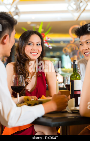 Four Asian Chinese business people having dinner in elegant club restaurant or hotel Stock Photo