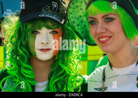 Two young women, one with her face painted in the colours of the Irish tricolour, during the St.Patrick's Day celebrations. Stock Photo