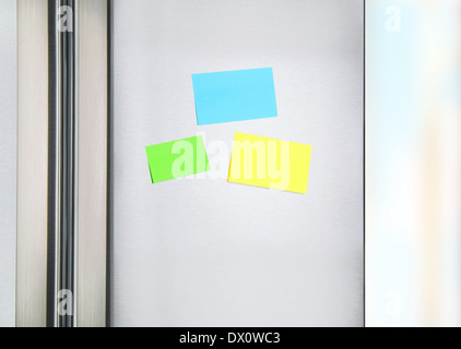 Sticky notes on the fridge, three colorful paper on the door of refrigerator for message, little reminder sheets Stock Photo