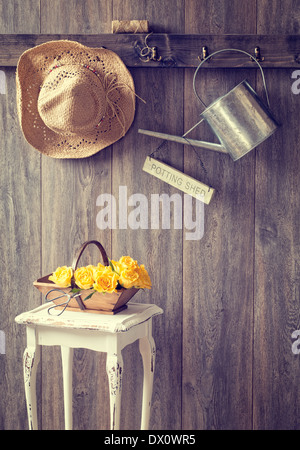 The potting shed with hanging straw hat and garden tools - vintage tone effect added Stock Photo