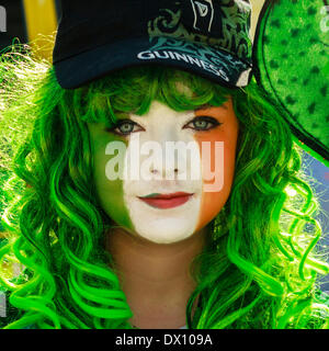 Young woman with her face painted in the colours of the Irish flag during the St.Patrick's Day celebrations. Stock Photo