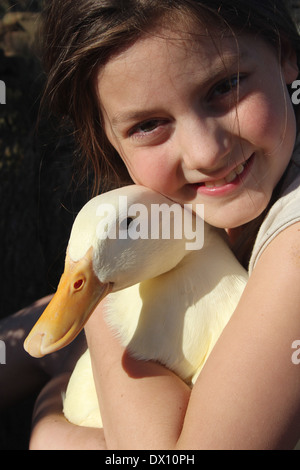 Young caucasian girl hugging her tame pet pekin duck (Anas platyrhynchos domestica or Anas peking) , UK, England Stock Photo