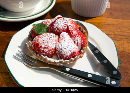 Strawberry tarts on white plate with fork and spoon Stock Photo