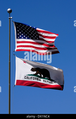 Flags of California and the United States of America blowing from flag pole in front of a blue sky, California, USA Stock Photo