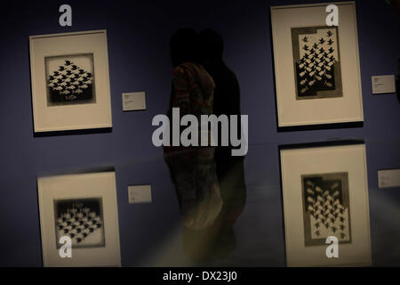 Taipei, China's Taiwan. 17th Mar, 2014. Visitors look at a work of Maurits Cornelis Esher, the famous Dutch print artist, at an art show in Taipei, southeast China's Taiwan, March 17, 2014. The exhibition 'The Enigma of M. C. Escher: Prints from the Israel Museum, Jerusalem', which lasts from Feb. 27 to June 2, includes Escher's best works, all from the collection of the Israel Museum, Jerusalem. Credit:  Huang Xiaoyong/Xinhua/Alamy Live News Stock Photo