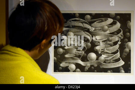 Taipei, China's Taiwan. 17th Mar, 2014. A man looks at a work of Maurits Cornelis Esher, the famous Dutch print artist, at an art show in Taipei, southeast China's Taiwan, March 17, 2014. The exhibition 'The Enigma of M. C. Escher: Prints from the Israel Museum, Jerusalem', which lasts from Feb. 27 to June 2, includes Escher's best works, all from the collection of the Israel Museum, Jerusalem. Credit:  Huang Xiaoyong/Xinhua/Alamy Live News Stock Photo