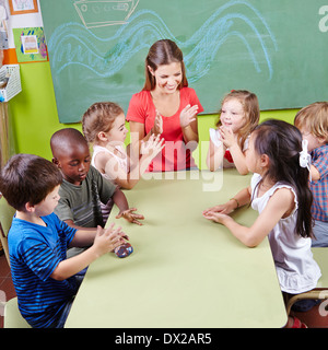 Group of children clapping hands in kindergarten in musical education class Stock Photo