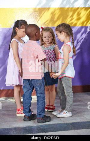 Four children dancing in circle in a kindergarten class Stock Photo