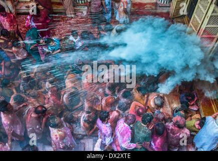 Calcutta. 17th Mar, 2014. Indian people sprinkle colour powder on the crowds at a temple during the celebration of Holi festival, also known as festival of colors, in Calcutta, capital of eastern Indian state West Bengal, March, 17, 2014. The Holi festival is a popular Hindu spring festival observed in India at the end of winter season on the last full moon day of the lunar month. Credit:  Tumpa Mondal/Xinhua/Alamy Live News Stock Photo