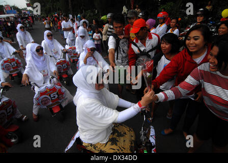 Central Java, Indonesia. 15th Feb, 2013. MARCH 15: Participant from Gerindra Party given flowers taken part on parade to mark opening of Indonesia election campaign in Indonesia on March 15, 2014 in Solo, Central Java, Indonesia. Indonesian elections will be held on April 9, 2014 while voting to Indonesia President election held July 9, 2014. Indonesia election followed by 12 parties with 180 million voters to take the part. © Sijori Images/ZUMAPRESS.com/Alamy Live News Stock Photo