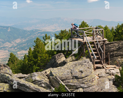 A female hiker admires the view from Izvidnica, on the climb to the 2601m peak of Pelister - Pelister National Park, Macedonia Stock Photo