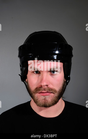 portrait of young man with beard and mustache in hockey helmet Stock Photo